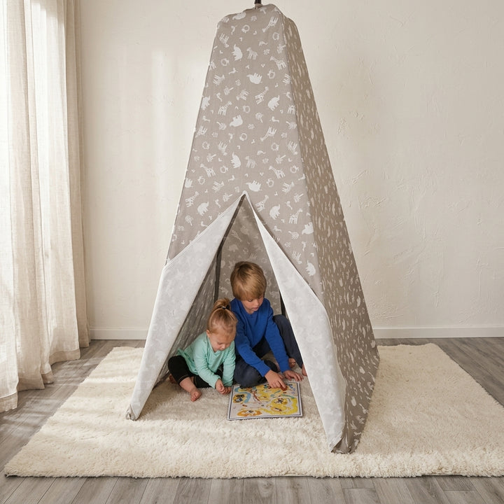Two children sitting and playing inside the Jolly Jumper Teepee Tent on a soft rug in a bright room